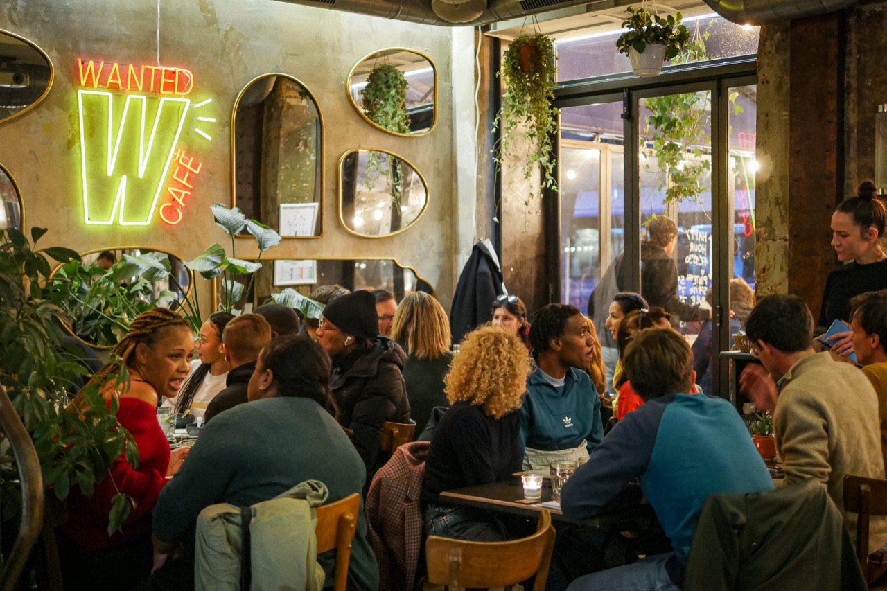 La salle du Wanted Café de Paris pleine de monde, sous le néon Wanted Café